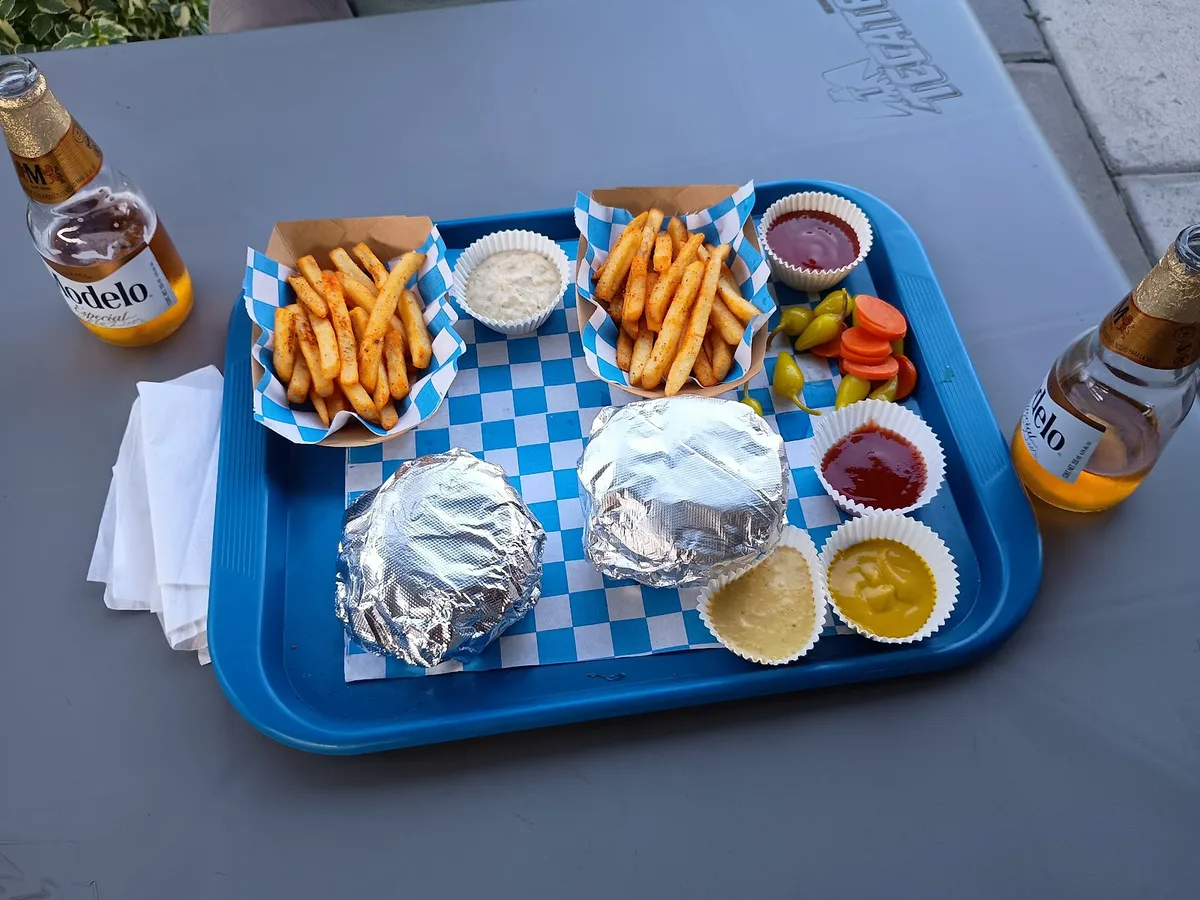 Charola con hamburguesas, papas y bebidas